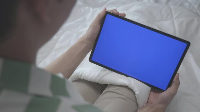 Asian Man looking To Tablet with Blue Screen And Laughing