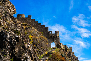 Entrance door and wall of the ruins of Tourbillon castle and Sion hill and city panorama in...