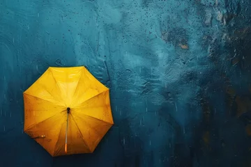 Fotobehang A vibrant yellow umbrella adorned with large raindrops, braving the downpour on a rainy day. © Murda
