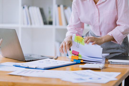 Happy asian young businesswoman   holding stack of documents in office working space, Female employee with stack of business overload paper concept.