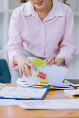 Happy asian young businesswoman   holding stack of documents in office working space, Female...