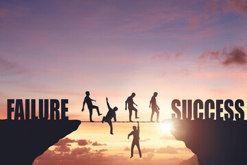 Silhouettes of people walking on a rope between rocks, success concept