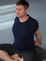 Attractive muscular man doing stretching back stretching exercises, warming up. Back pain relief, Sport injury prevention concept, copy space.