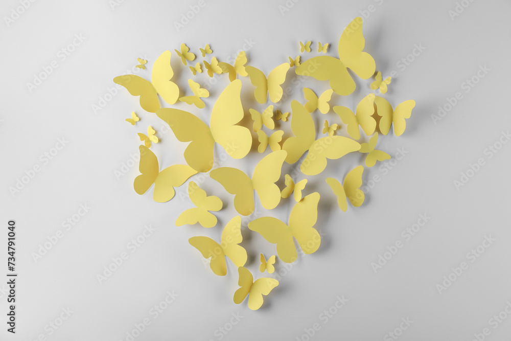 Sticker Heart shape made of yellow paper butterflies on white background, top view