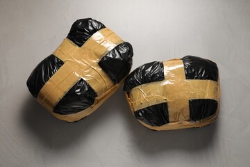 Packages with narcotics on grey textured table, top view