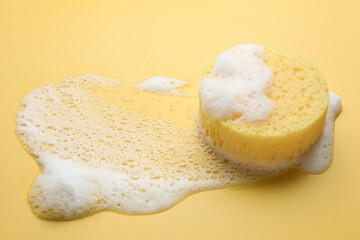 Sponge with foam on yellow background. Space for text