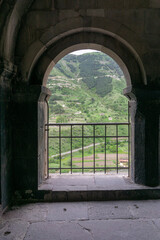 View of the mountain through the church arch and railings. Vardzia is a cave monastery, an ancient rock-hewn town, was excavated in the Erusheti Mountain.
