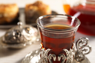 Glass of traditional Turkish tea in vintage holder on table, closeup. Space for text