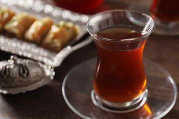 Traditional Turkish tea in glass on wooden table, closeup. Space for text