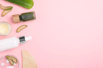 Cosmetic products, cut aloe leaves and gua sha tool on pink background, flat lay. Space for text