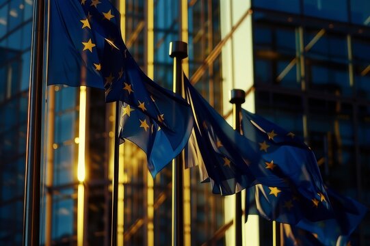 Group Of Flags Of The European Union Waving In The Wind In Front Of The European Parliament Building Concept