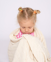 A pretty little girl wrapped herself in a warm blanket