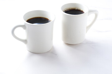 淹れたてのコーヒーが入ったふたつのマグカップ
