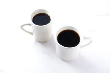 淹れたてのコーヒーが入ったふたつのマグカップ
