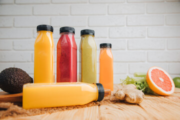 Fruit and vegetable smoothies in transparent plastic bottles. Red, green, orange smoothies on a wooden table. The concept of healthy eating. Front view
