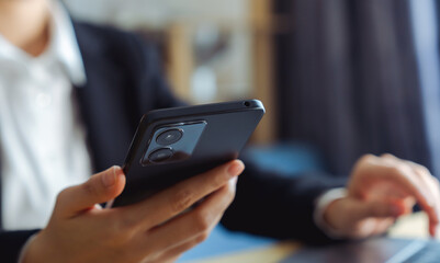 The business manager uses a smartphone and its apps for customer support, including email, chat, and phone communication.