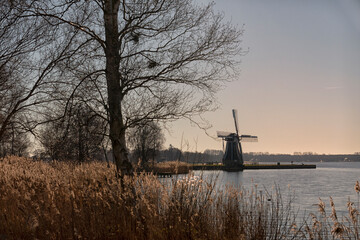Windmill on a lake in the Netherlands - 734803837