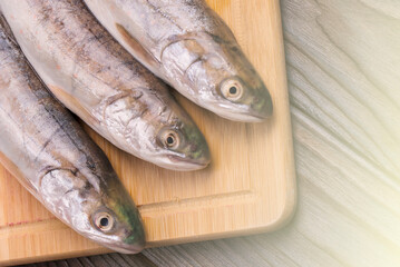 Fresh fish on the board. on the wooden background on sunlight