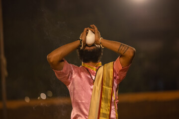 Ganga aarti, Portrait of young priest performing holy river ganges evening aarti at dashashwamedh...