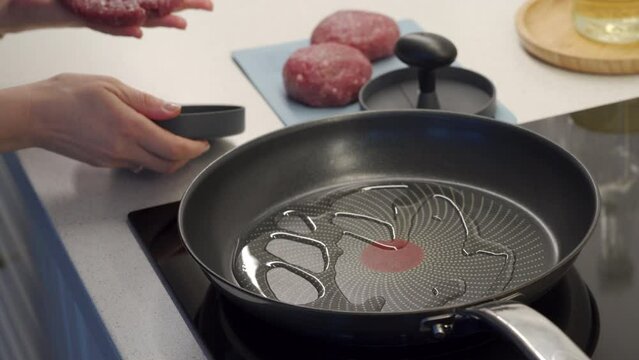 preparing delicious and juicy homemade hamburger patties, frying beef cutlets in a frying pan