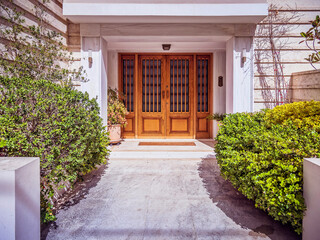 A wood and glass entrance door of a contemporary luxury apartment building. Visit Athens posh...