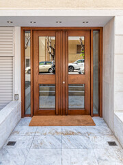 A wood and glass entrance door of a contemporary luxury apartment building. Visit Athens posh...