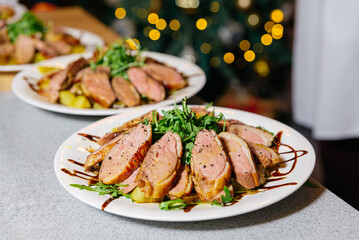 Roast Duck Slices on Plate with Arugula and Balsamic. Succulent slices of roast duck served on a white plate, garnished with fresh arugula and drizzled with balsamic glaze, festive background.