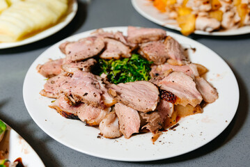 Herb-Crusted Roast Pork Slices on White Plate. Herb-crusted roast pork sliced and plated with garnish, showcasing the juicy tenderness and savory flavors of the meat.