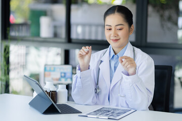 Asian female doctor working with laptop and health personal data in modern clinic, Healthcare and...