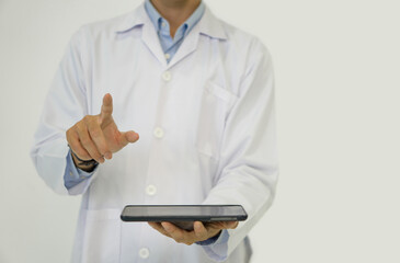 A doctor in a white lab coat holding blank screen tablet computer pointing finger toward with his hand. Portrait on white background, studio shot.