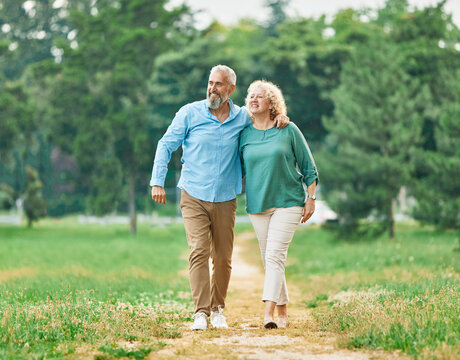 woman man mature couple happy together active bonding park outdoor middle aged talking leisure park fun smiling love old middle mid aged nature wife walking