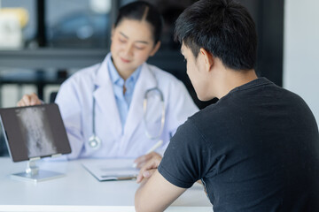 Obraz premium Asian female doctor explain to patient and looking at xrays indoors office, healthcare and medical concept.