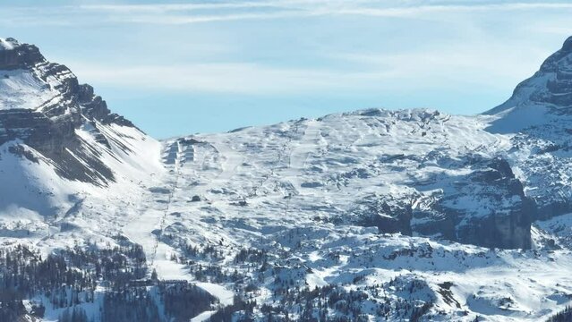 Aerial drone view of Madonna di Campiglio and ursus snowpark in Val Rendena dolomites trentino Italy. Snowboarder skier jumps on kicker in snowpack.
