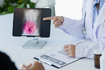 Asian female doctor explain to patient and looking at xrays indoors office, healthcare and medical concept.