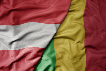 big waving national colorful flag of mali and national flag of austria .
