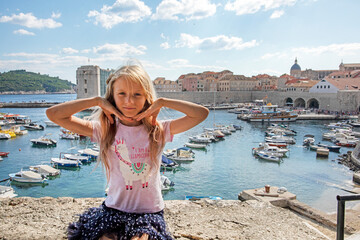 girl with long hair against the backdrop of the port in Dubrovnik in Croatia. euro-trip