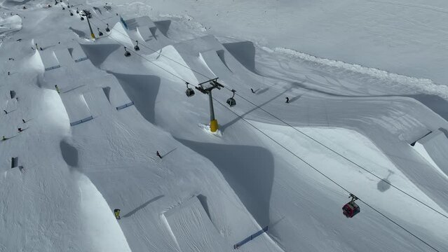 Aerial drone view of Madonna di Campiglio and ursus snowpark in Val Rendena dolomites trentino Italy. Snowboarder skier jumps on kicker in snowpack.
