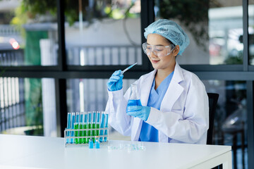 Asian female scientist or medical technician working with a blood lab test in the research lab,...