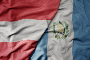big waving national colorful flag of guatemala and national flag of austria .