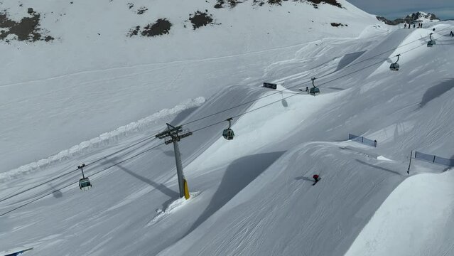 Aerial drone view of Madonna di Campiglio and ursus snowpark in Val Rendena dolomites trentino Italy. Snowboarder skier jumps on kicker in snowpack.
