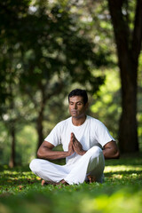 Indian man doing yoga exercise in a forest