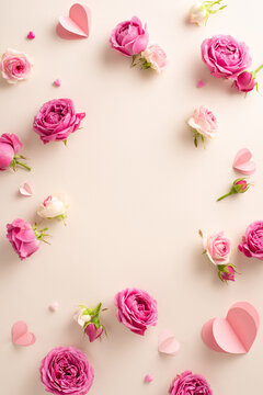 Welcoming International Women's Day, a photograph from top view of fragile paper hearts alongside blooming roses on a subdued beige backdrop, with ample space left for any text or advert