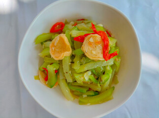 Selective focus. Sayur Labu Siam or Manisa or Jipang or Chayote. Indonesian food. Sayur Godog Labu Siem served in a bowl, isolated on white background. Top view.
