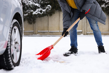 Man removing snow with shovel near car outdoors, closeup