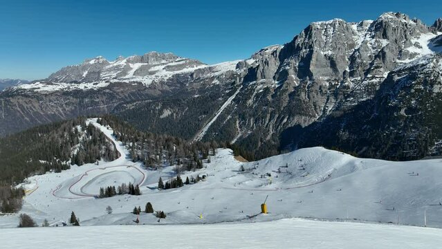 Aerial drone Winter view on dolomites alps in Italy.  Pinzolo in winter sunny day.  Paragliding mountains.
Sitting on bench in dolomites in winter. Val Rendena dolomites  Italian alps, Trentino Italy.