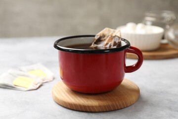 Brewing tea. Cup with tea bag on light table