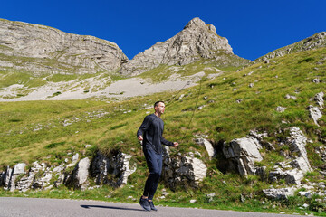 Endurance training in the mountains. A man jumps on a rope on the background of a beautiful...