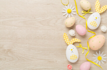 Easter eggs and decoration on wooden background, top view