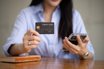 Young asian businesswoman using a credit card with smartphone at at office, Happy shopping online and credit card concept.