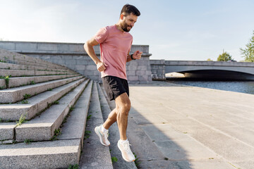 Man in casual workout gear running up the city stairs, enjoying an active lifestyle with urban exercise